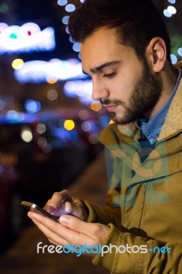 Portrait Of Young Man Using His Mobile Phone On The Street At Ni… Stock Photo