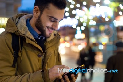 Portrait Of Young Man Using His Mobile Phone On The Street At Ni… Stock Photo