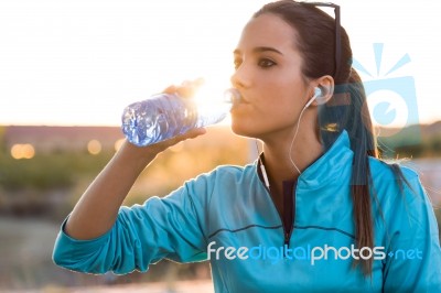 Portrait Of Young Woman Drinking Water After Running Stock Photo