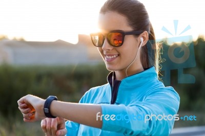 Portrait Of Young Woman Using They Smartwatch After Running Stock Photo