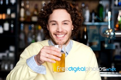 Positive Young Man Holding A Glass Of Beer Stock Photo