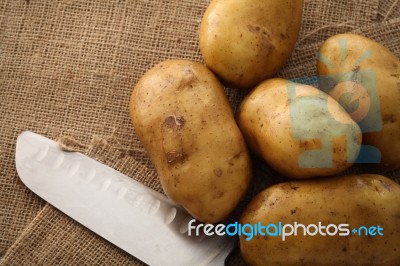 Potato On Still Life Sack Background Stock Photo