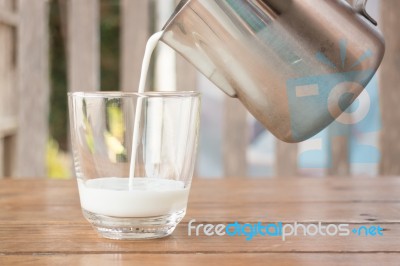 Pour Milk From A Pitcher Into A Glass Stock Photo