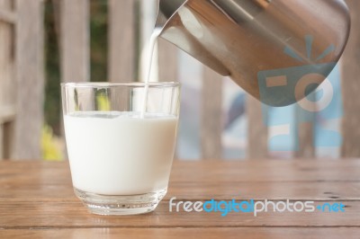 Pour Milk From A Pitcher Into A Glass Stock Photo