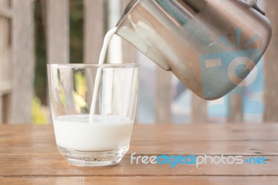 Pour Milk From A Pitcher Into A Glass Stock Photo