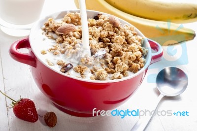 Pour Milk Into The Bowl For Healthy Breakfast Stock Photo