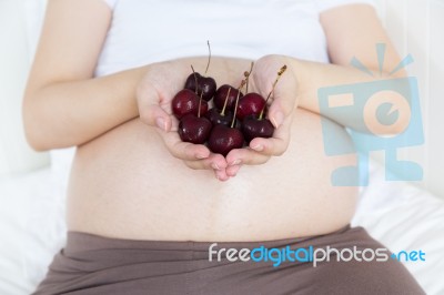 Pregnant Belly With Cherry Stock Photo