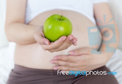 Pregnant Belly With Green Apple Stock Photo