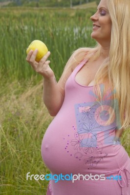 Pregnant Woman Holding Apple Stock Photo