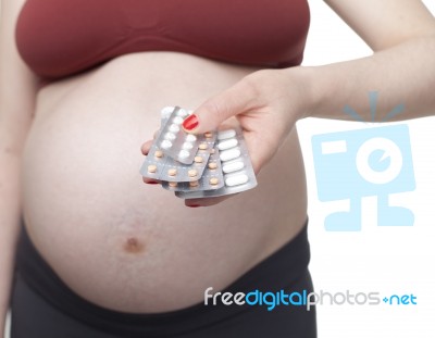 Pregnant Woman Holding Pills Stock Photo