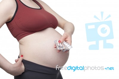 Pregnant Woman Holding Pills Stock Photo