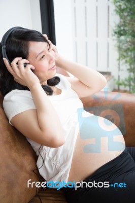 Pregnant Woman Listen To The Music Stock Photo