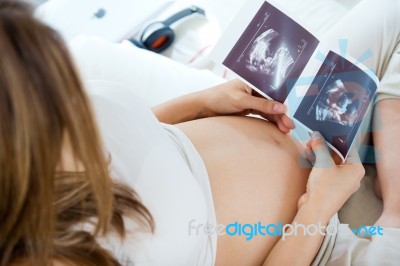 Pregnant Woman Looking At Ultrasound Scan Of Baby Stock Photo