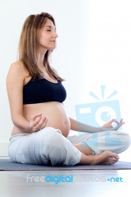 Pregnant Woman Relax Doing Yoga, Sitting In Lotus Position Stock Photo