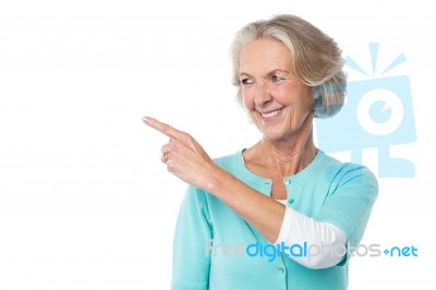 Pretty Aged Woman Pointing At Something Stock Photo