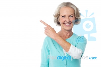 Pretty Aged Woman Pointing At Something Stock Photo