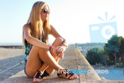 Pretty Blonde Girl Sitting On The Roof Stock Photo