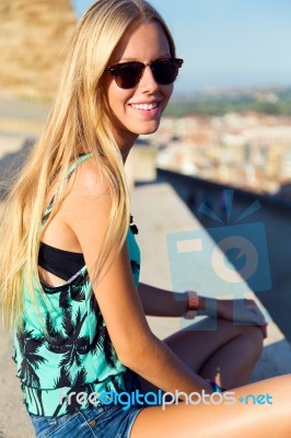 Pretty Blonde Girl Sitting On The Roof Stock Photo