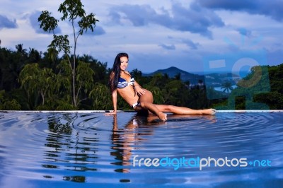 Pretty Brunette Model In Bikini Posing At The Pool Stock Photo