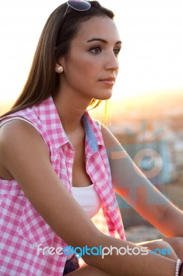 Pretty Girl Sitting On The Roof At Sunset Stock Photo