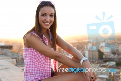 Pretty Girl Sitting On The Roof At Sunset Stock Photo