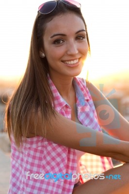 Pretty Girl Sitting On The Roof At Sunset Stock Photo