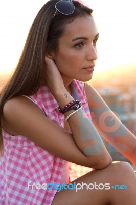 Pretty Girl Sitting On The Roof At Sunset Stock Photo