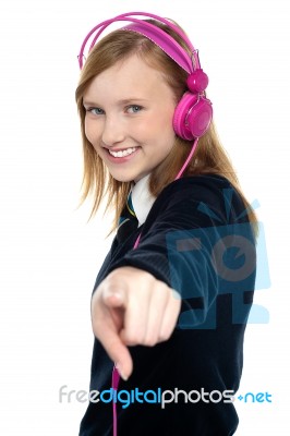 Pretty Musical Girl Enjoying Music And Pointing At You Stock Photo