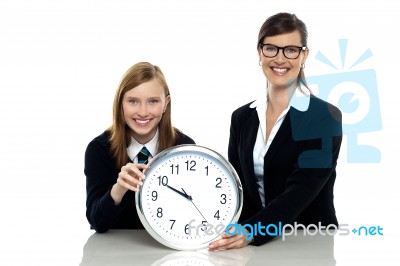 Pretty Student Holding Clock With Her Teacher Stock Photo