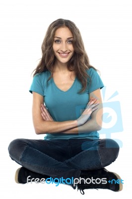 Pretty Woman Seated On The Floor With Hands Crossed Stock Photo