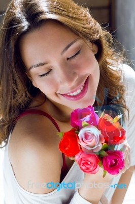 Pretty Woman With Flowers At Home Stock Photo