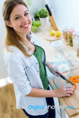 Pretty Young Woman Cutting Vegetables In The Kitchen Stock Photo