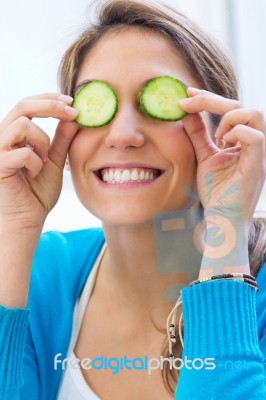 Pretty Young Woman Having Fun With A Cucumber In The Kitchen Stock Photo