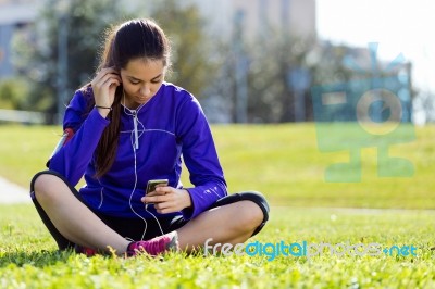 Pretty Young Woman Listening To Music After Running Stock Photo