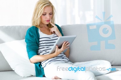 Pretty Young Woman Using Her Digital Tablet At Home Stock Photo