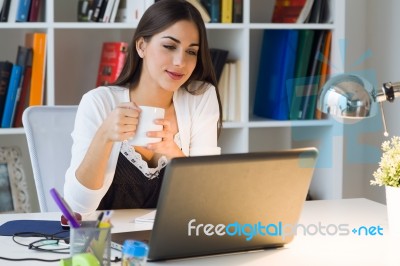 Pretty Young Woman Working With Laptop In Her Office Stock Photo