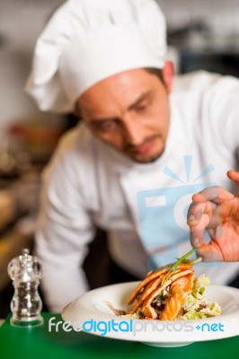 Professional Chef Preparing Baked Salmon To Be Served Stock Photo