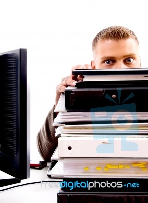 Professional Man Peeping From Files In Office Stock Photo