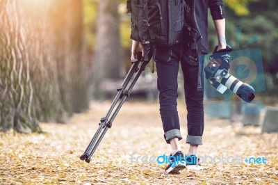 Professional Photographer With Camera And Tripod In Autumn. Vintage Tone Stock Photo