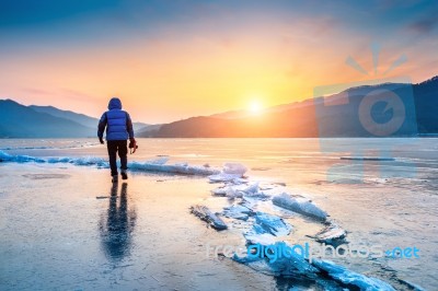 Professional Photographer With Camera On Frozen River In Winter Stock Photo