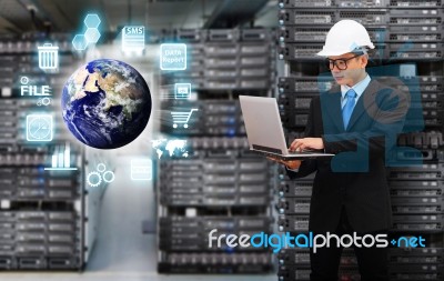 Programmer In Data Center Room Working With Laptop Stock Photo