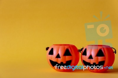 Pumpkins Bucket On Yellow Background , Halloween Background Stock Photo