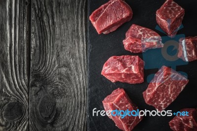 Raw Angus Beef Slices On The Black Stone  On The Wooden Table Horizontal Stock Photo