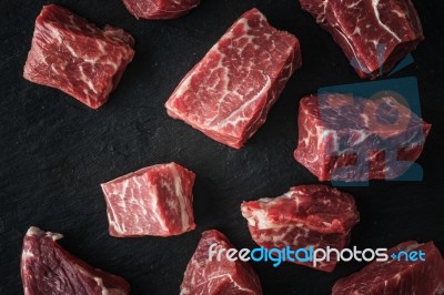 Raw Angus Beef Slices On The Black Stone  Table Stock Photo