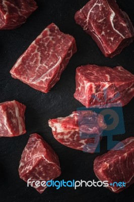 Raw Angus Beef Slices On The Black Stone  Table Vertical Stock Photo