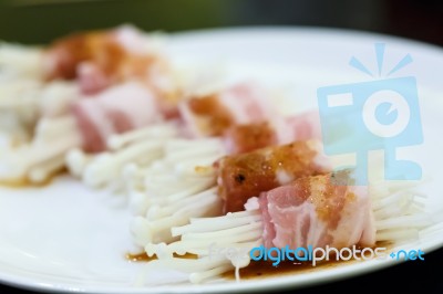 Raw Bacon Wrapped With Needle Mushroom Stock Photo