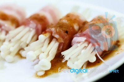 Raw Bacon Wrapped With Needle Mushroom Stock Photo