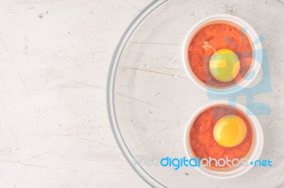 Raw Eggs With Tomatoes In The Ramekins On The White  Wooden Table Top View Stock Photo