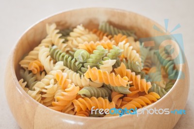 Raw Fusilli Pasta On Wooden Bowl Stock Photo