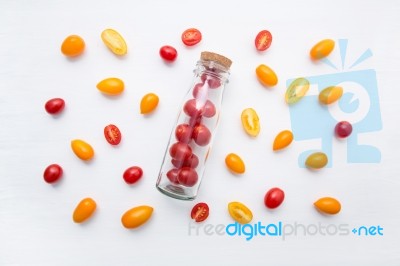 Red And Yellow Cherry Tomatoes On A White Background Stock Photo